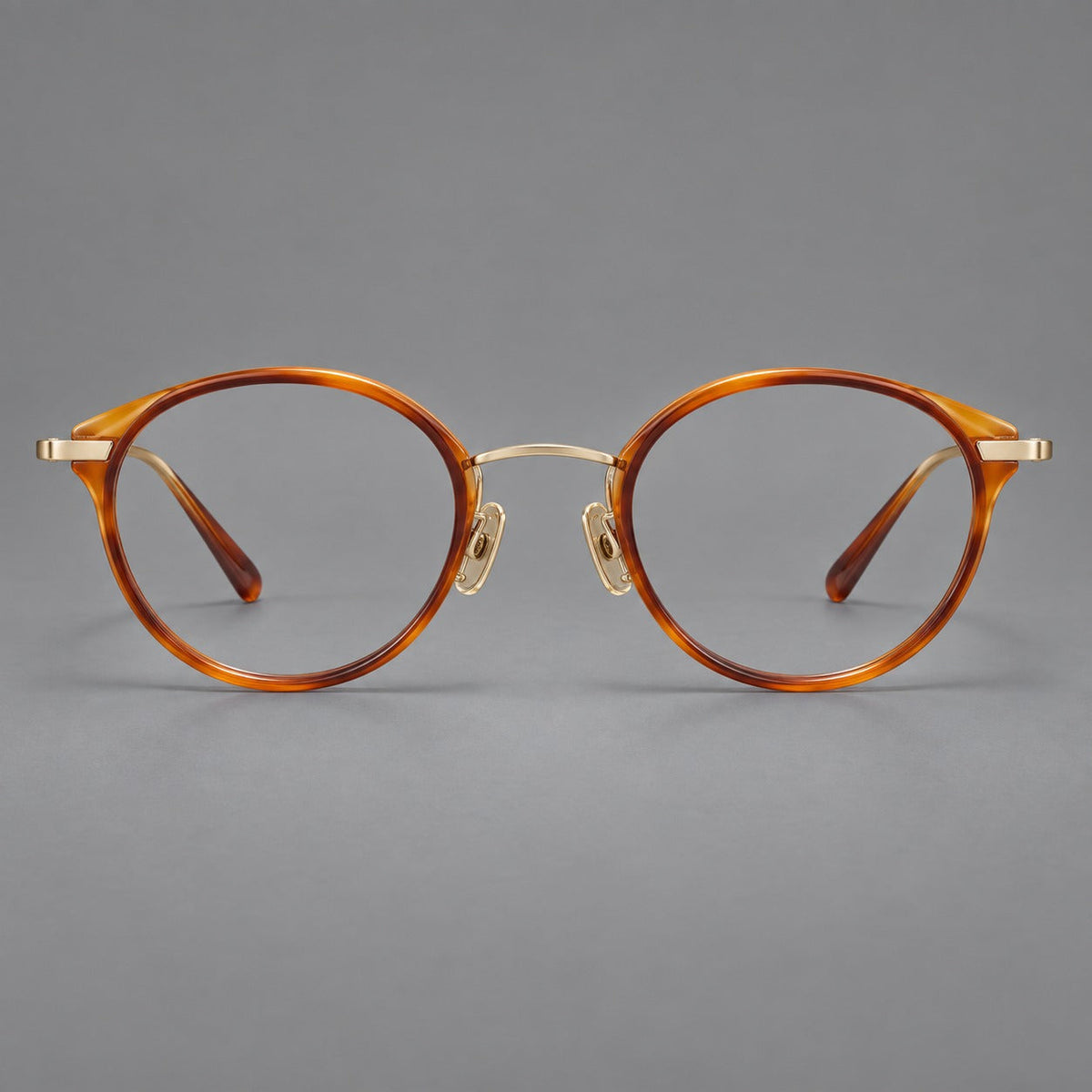 Retro panto eyeglasses in acetate and titanium with an arched bridge and engraved metal temples in Amber Tortoiseshell / Light Gold, front view