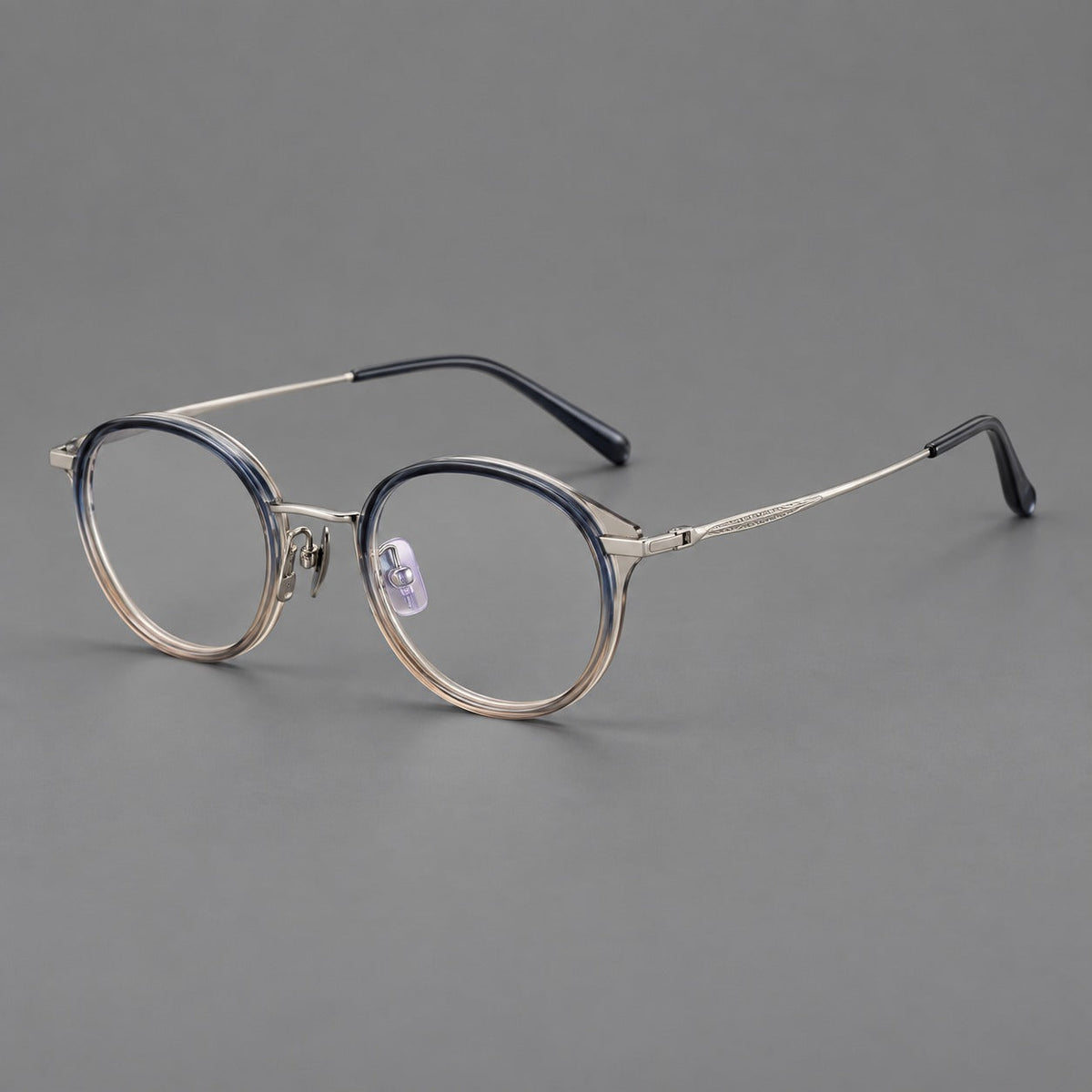 Retro panto eyeglasses in acetate and titanium with an arched bridge and engraved metal temples in Gray Blue Tea Gradient / Light Gunmetal, three quarter view