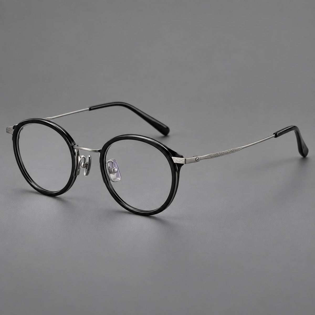 Retro panto eyeglasses in acetate and titanium with an arched bridge and engraved metal temples in Glossy Black / Matte Gunmetal, three quarter view