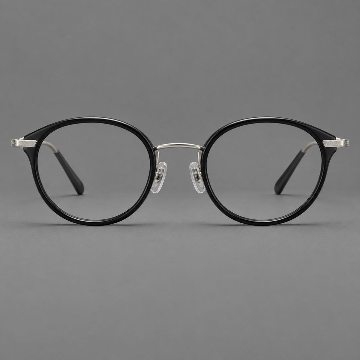 Retro panto eyeglasses in acetate and titanium with an arched bridge and engraved metal temples in Glossy Black / Matte Gunmetal, front view