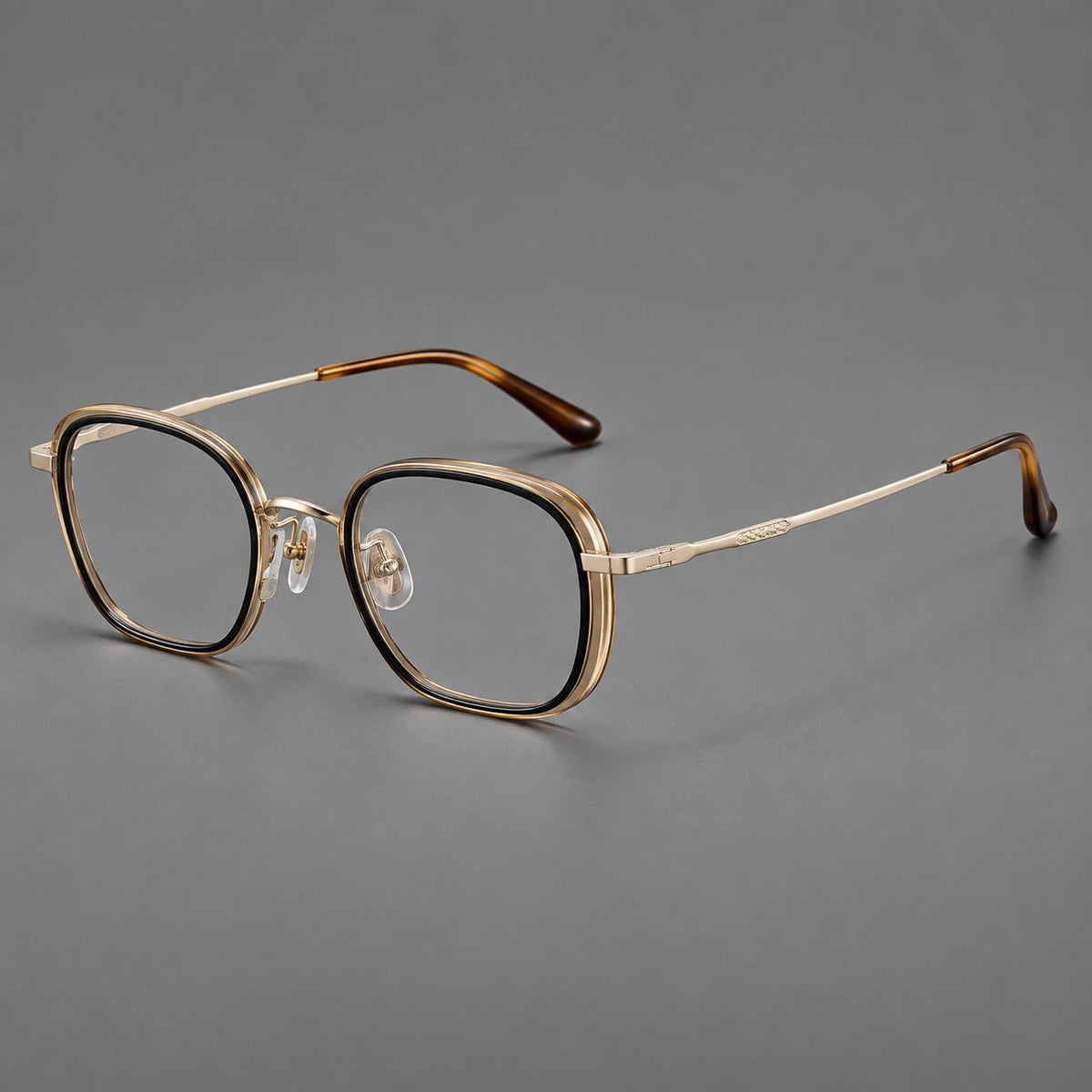 Rounded square eyeglasses in acetate and titanium with an arched bridge and engraved temples in Black and Clear Tea / Light Gold, three quarter view