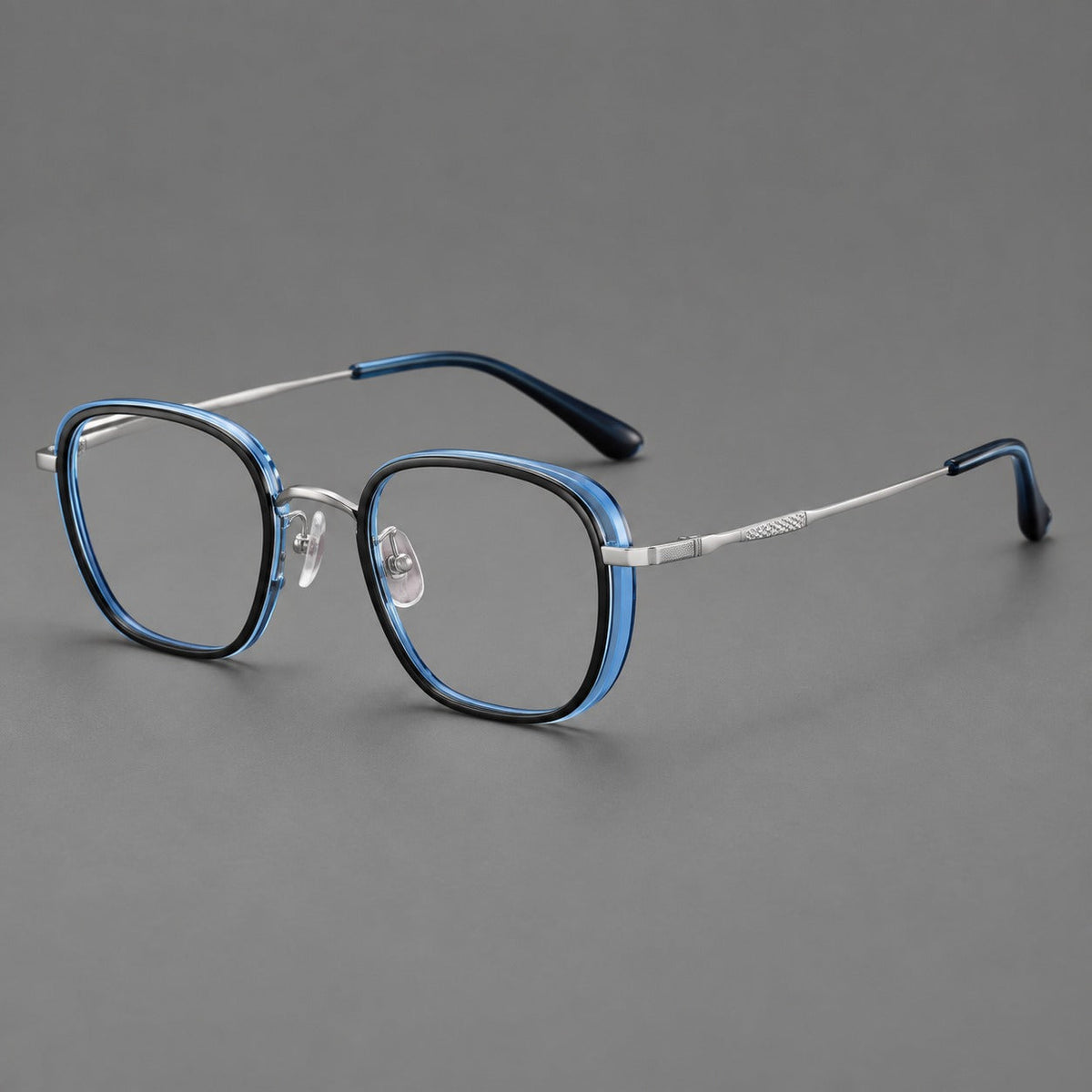 Rounded square eyeglasses in acetate and titanium with an arched bridge and engraved temples in Black and Clear Blue / Silver, three quarter view