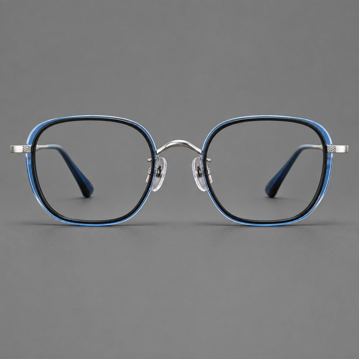 Rounded square eyeglasses in acetate and titanium with an arched bridge and engraved temples in Black and Clear Blue / Silver, front view
