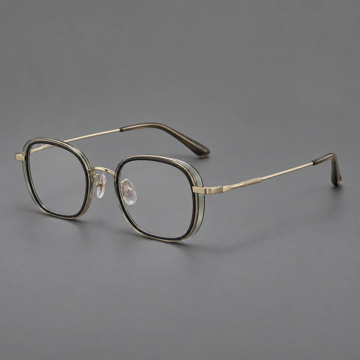 Rounded square eyeglasses in acetate and titanium with an arched bridge and engraved temples in Clear Tea Gray Green / Light Gold, three quarter view