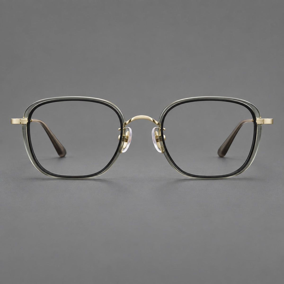 Rounded square eyeglasses in acetate and titanium with an arched bridge and engraved temples in Clear Tea Gray Green / Light Gold, front view