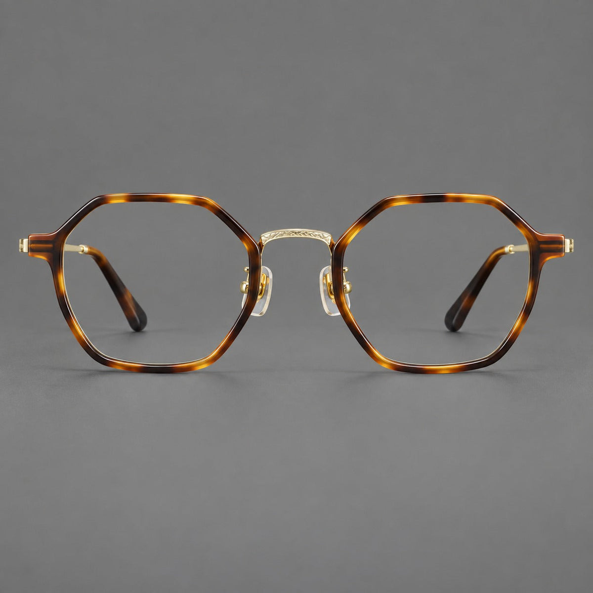 Geometric eyeglasses in acetate and titanium with octagonal rims and a textured metal bridge in Amber Tortoiseshell / Light Gold, front view