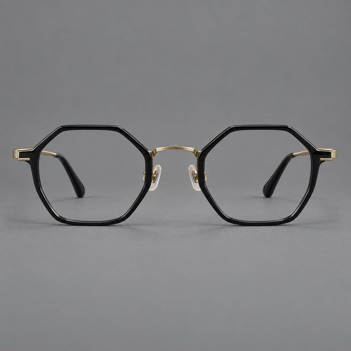 Geometric eyeglasses in acetate and titanium with octagonal rims and a textured metal bridge in Glossy Black / Antique Gold, front view