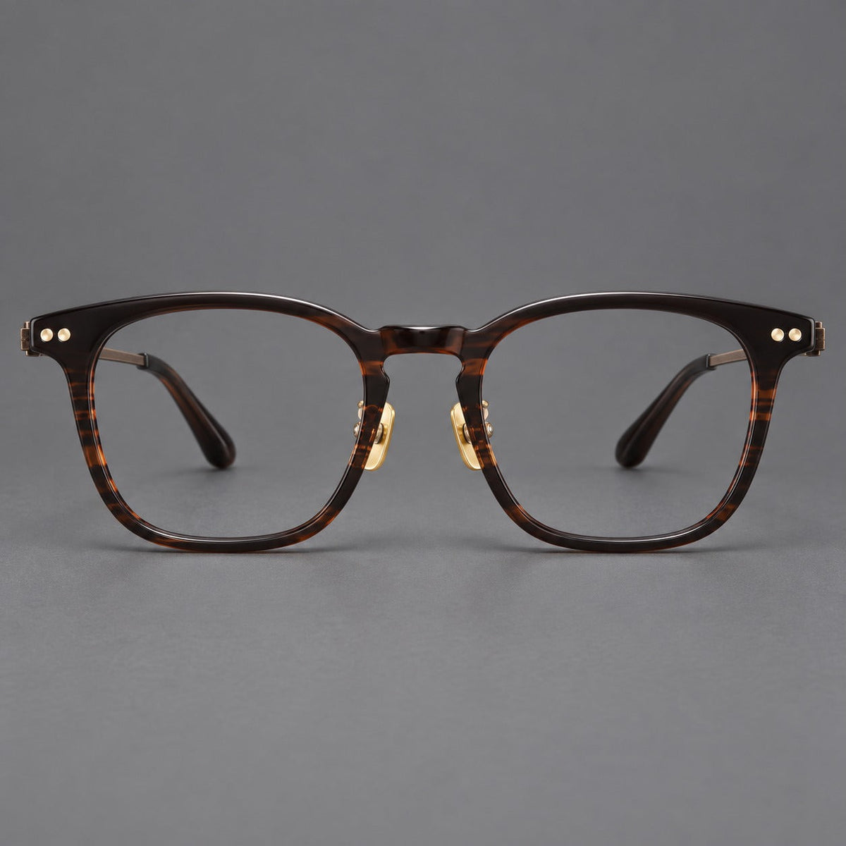 Retro acetate and titanium eyeglasses with gently squared rims and circular metal hinges in Striped Dark Brown / Antique Bronze, front view