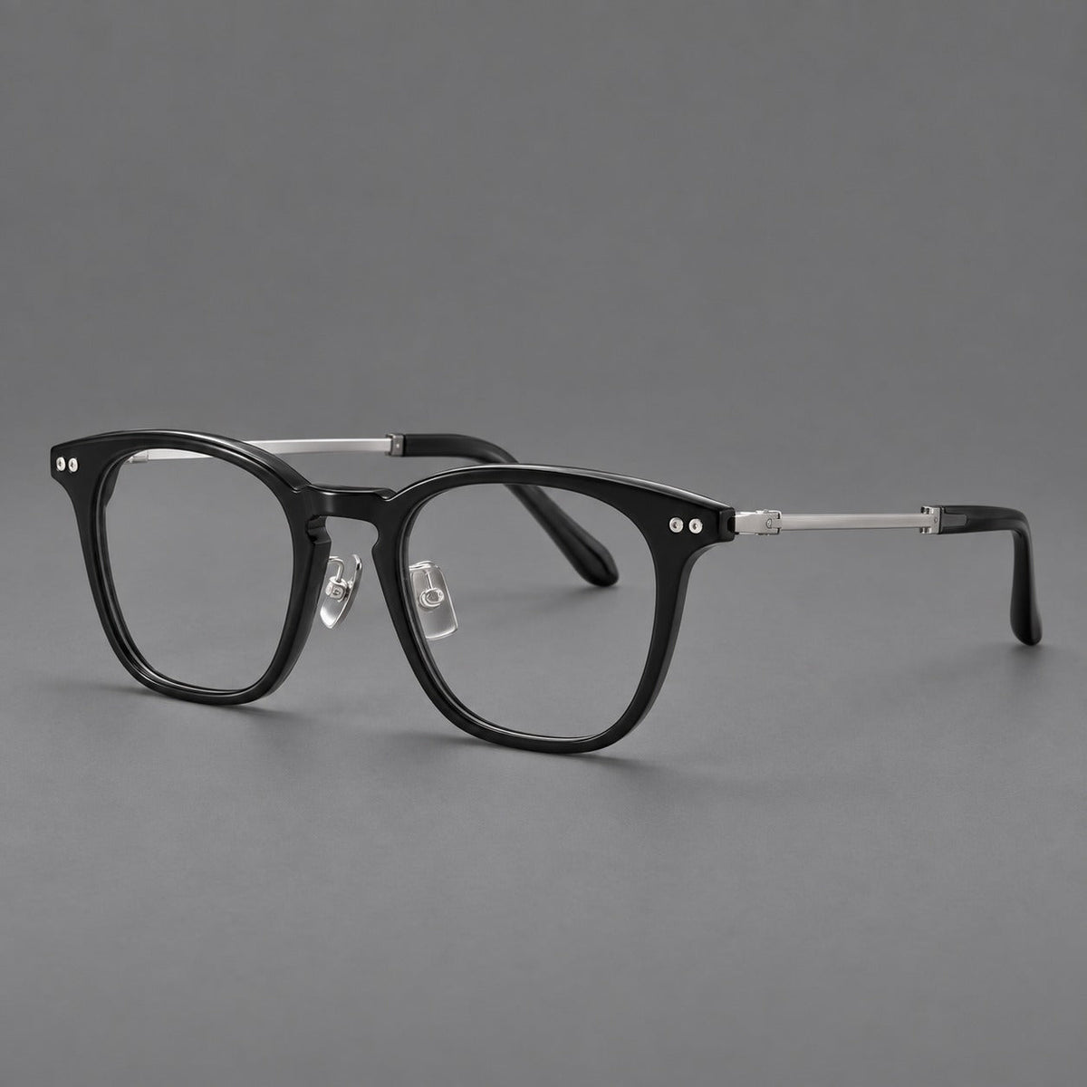 Retro acetate and titanium eyeglasses with gently squared rims and circular metal hinges in Black / Silver, three quarter view