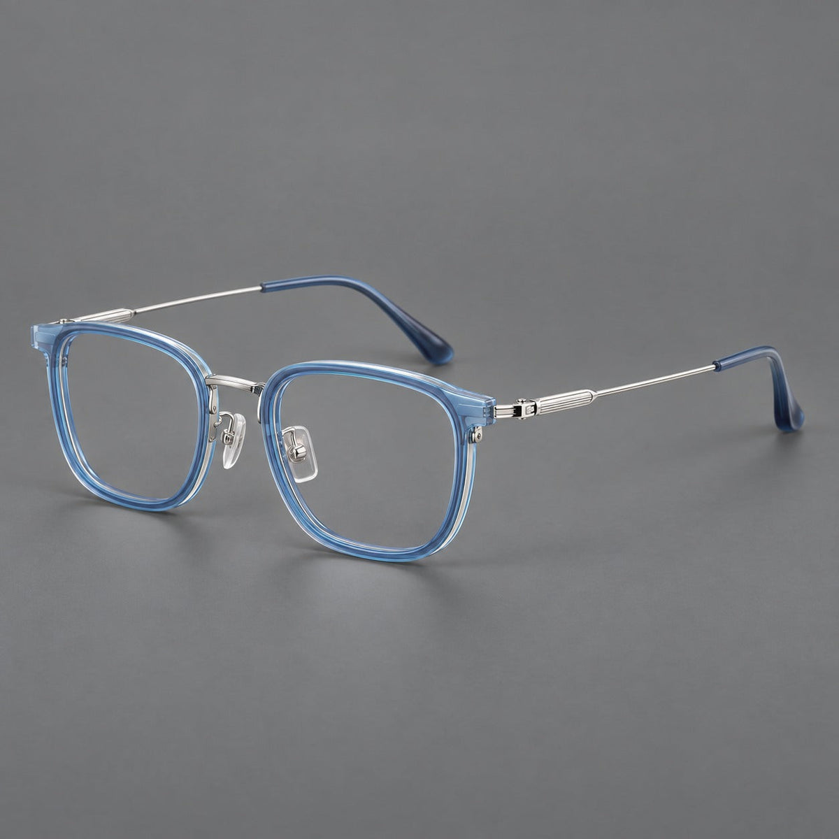 Soft square eyeglasses in acetate and titanium with wide upper corners and fine metal temples in Clear Blue / Silver, three quarter view