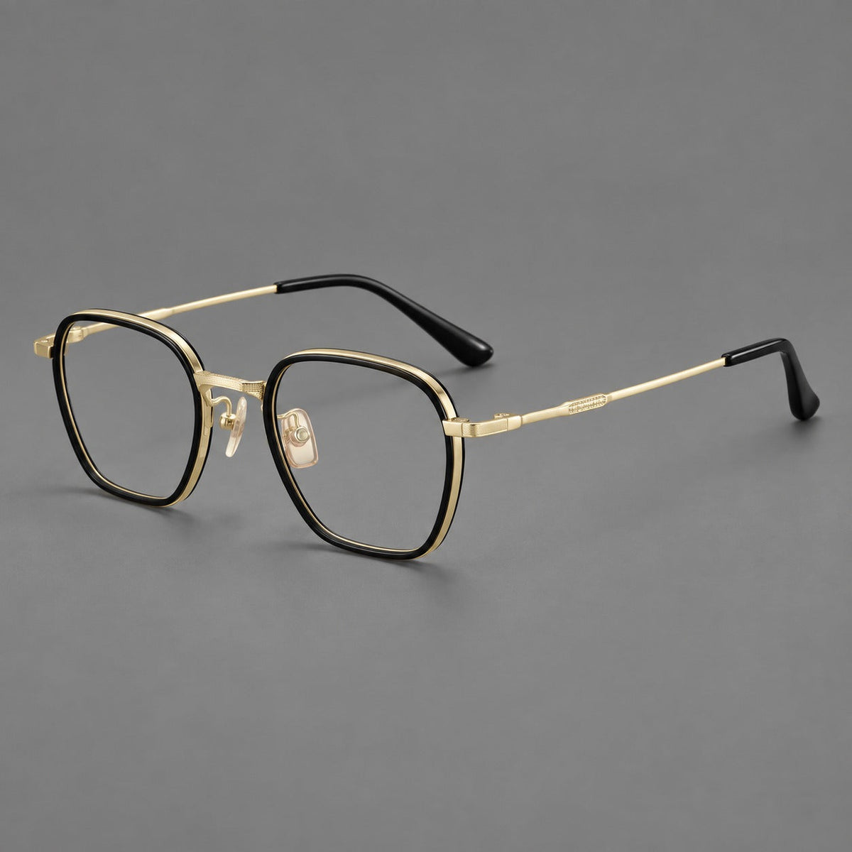 Soft square eyeglasses in acetate and titanium with slim rims and a finely engraved metal bridge in Glossy Black / Gold, three quarter view