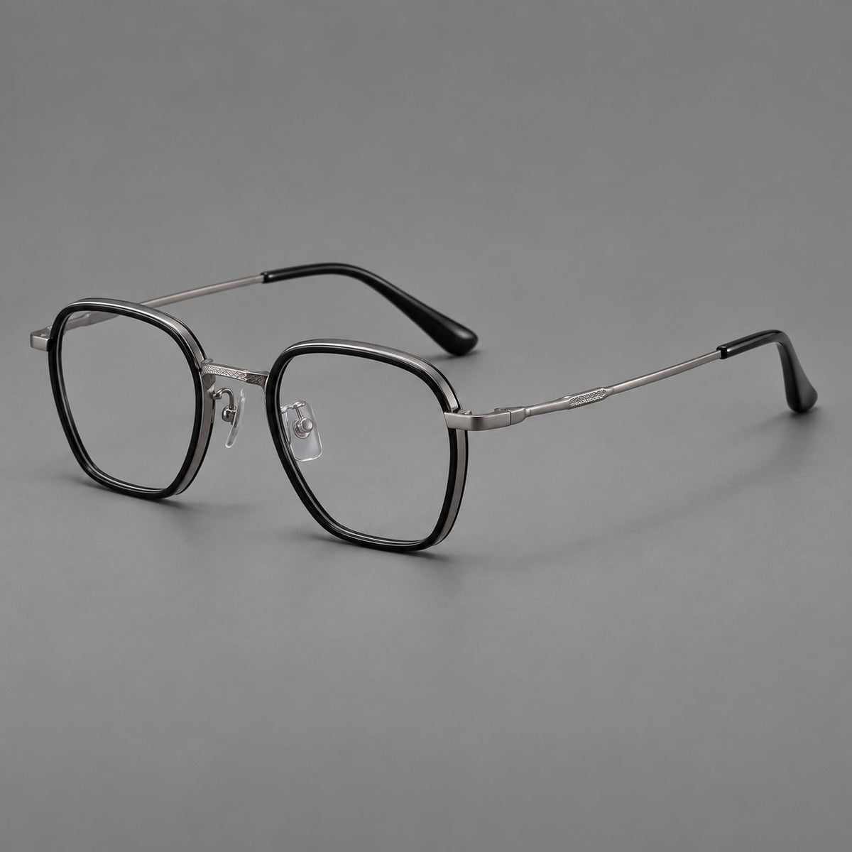 Soft square eyeglasses in acetate and titanium with slim rims and a finely engraved metal bridge in Glossy Black / Gunmetal, three quarter view