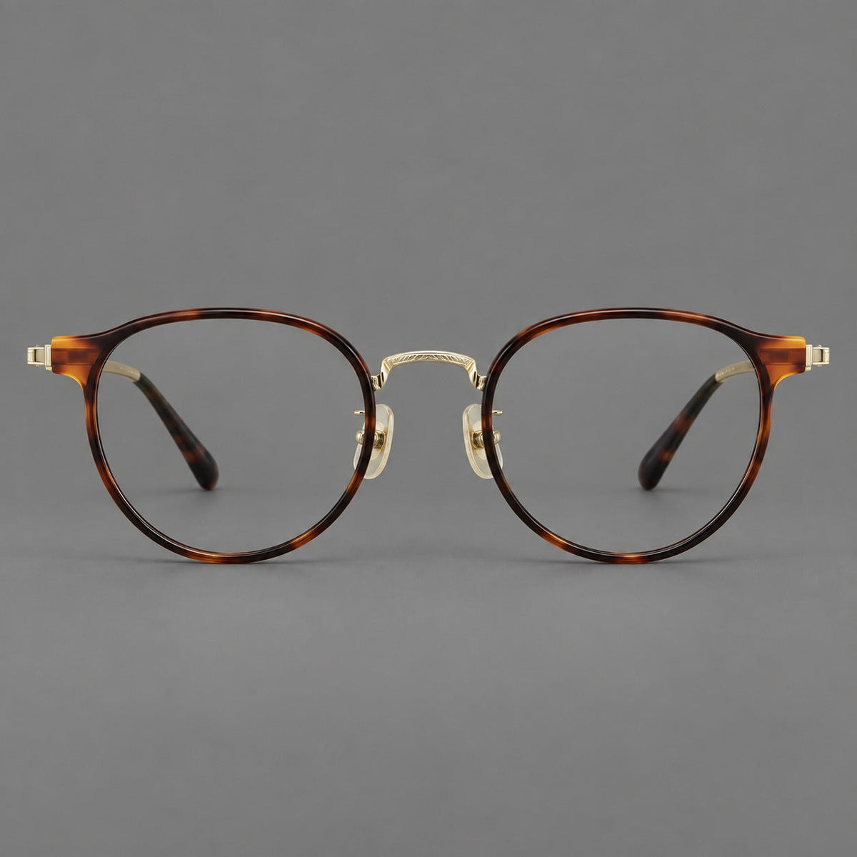 Round eyeglasses in acetate and titanium with widened outer corners and slender metal temples in Tortoiseshell / Gold, front view
