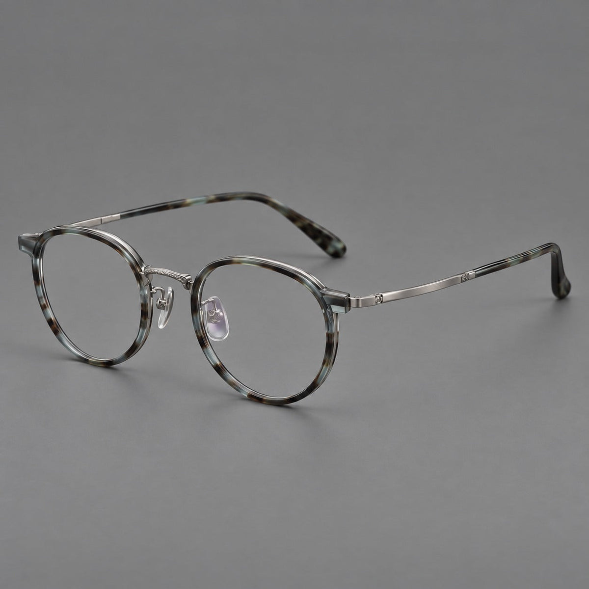 Round eyeglasses in acetate and titanium with widened outer corners and slender metal temples in Green Gray Tortoiseshell / Gunmetal, three quarter view
