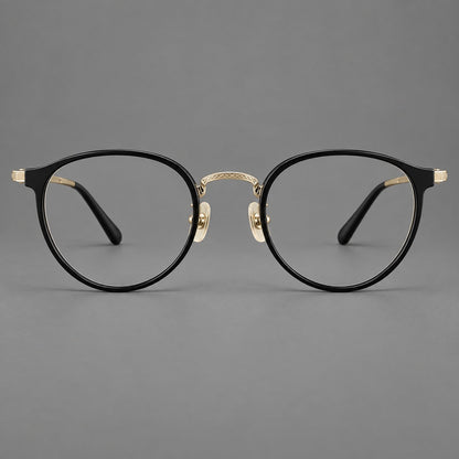 Round eyeglasses in acetate and titanium with widened outer corners and slender metal temples in Glossy Black / Gold, front view temple detail