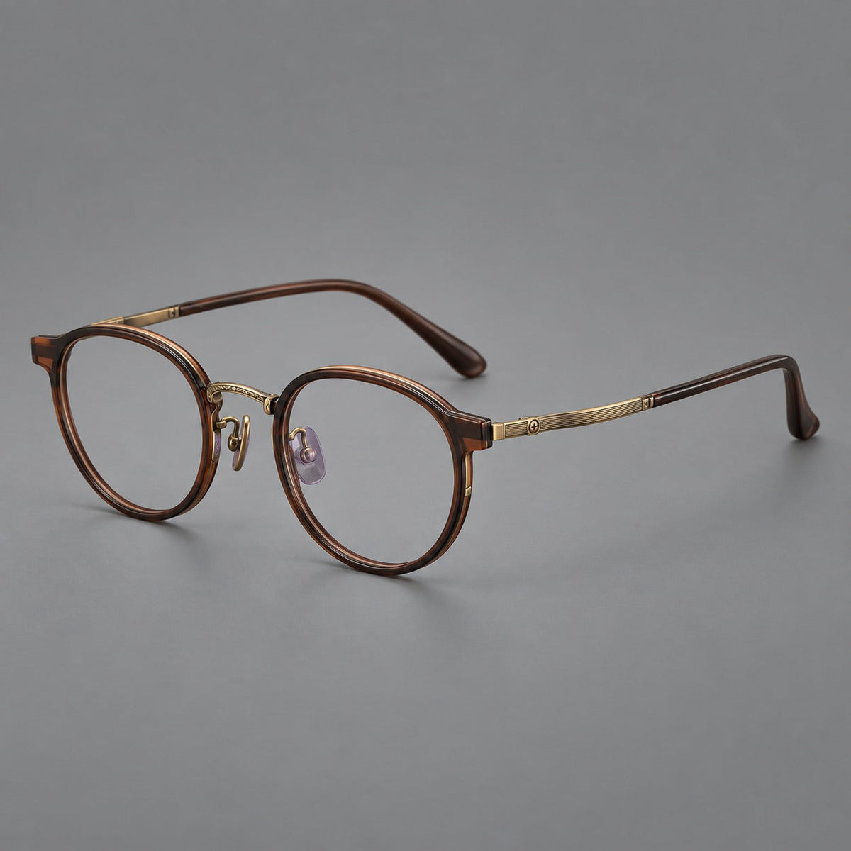 Round eyeglasses in acetate and titanium with widened outer corners and slender metal temples in Coffee Brown / Antique Bronze, three quarter view