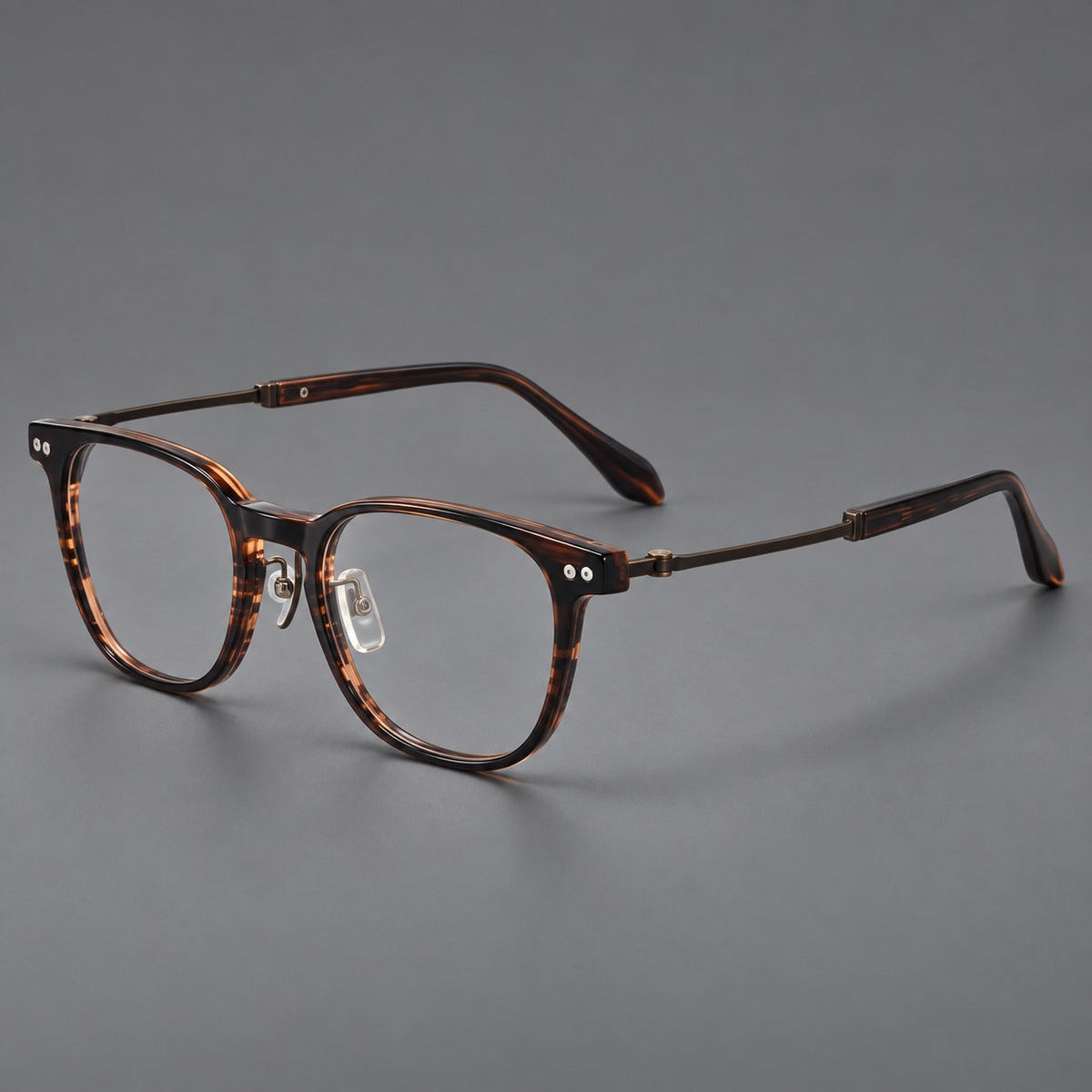 Vintage acetate and titanium eyeglasses with soft square rims and paired metal rivets in Striped Brown / Antique Bronze, three quarter view