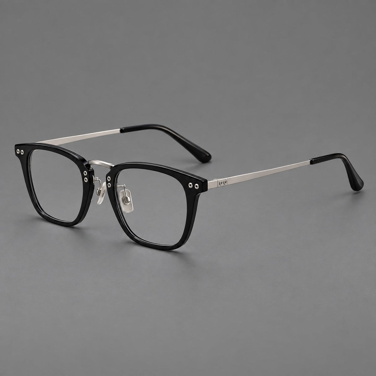 Acetate and titanium eyeglasses with soft square rims and an arched metal bridge in Black / Silver, three quarter view