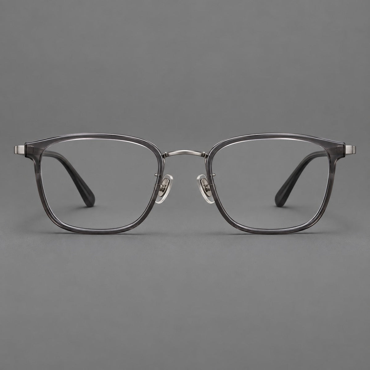 Rounded rectangular eyeglasses in acetate and titanium with bold corners and engraved metal temples in Clear Gray / Gunmetal, front view