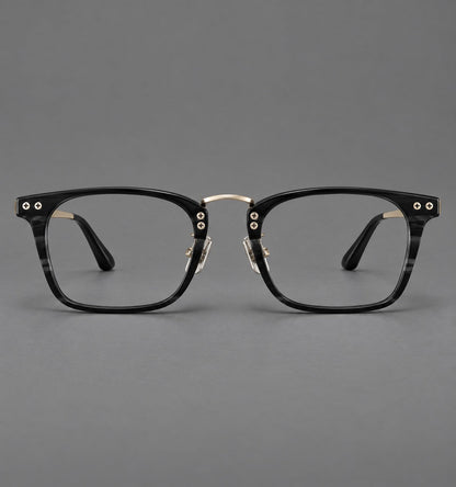 Acetate and titanium eyeglasses with angular rectangular rims and a curved metal bridge in Black / Gold, front view temple detail