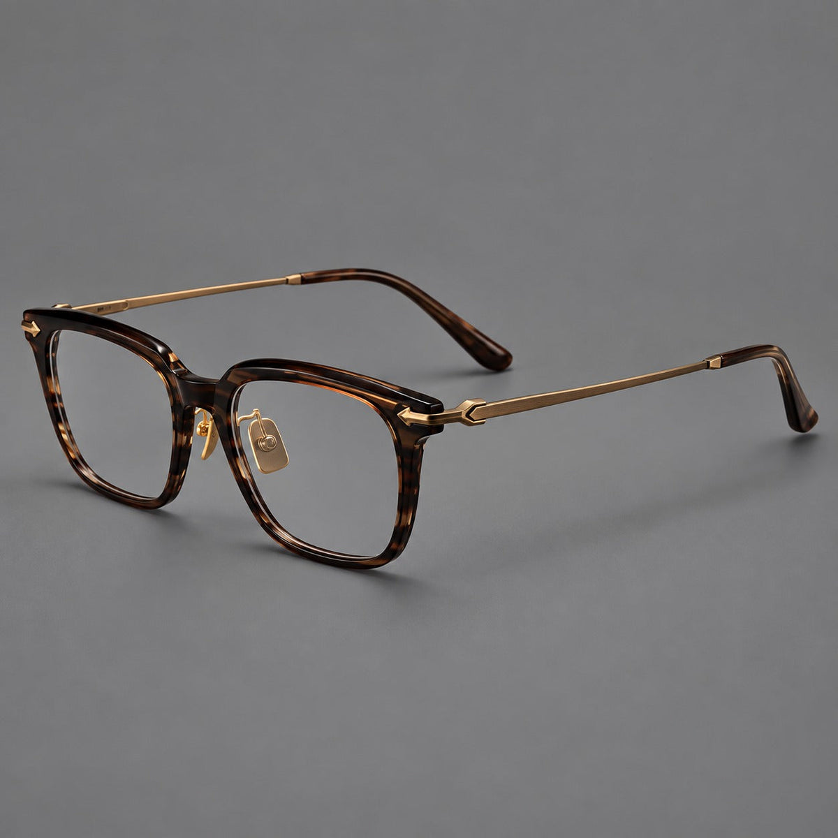 Bold acetate and titanium eyeglasses with rectangular rims and sculpted arrow accents in Tea Woodgrain / Antique Bronze, three quarter view