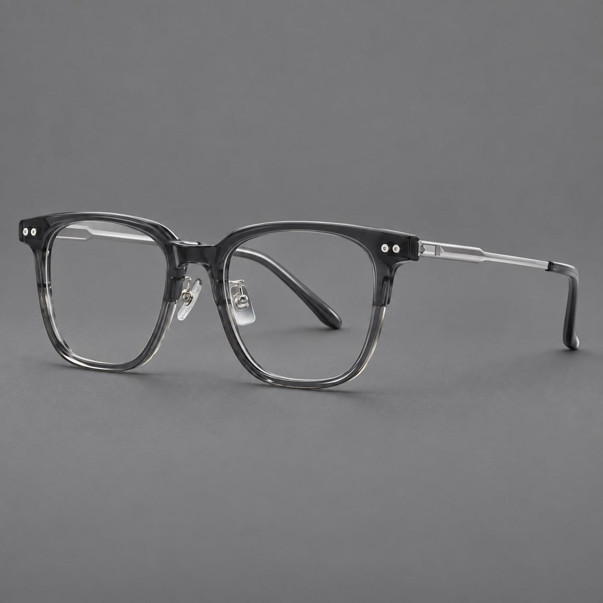 Classic acetate and titanium eyeglasses with squared brows and paired corner rivets in Clear Gray / Silver, three quarter view