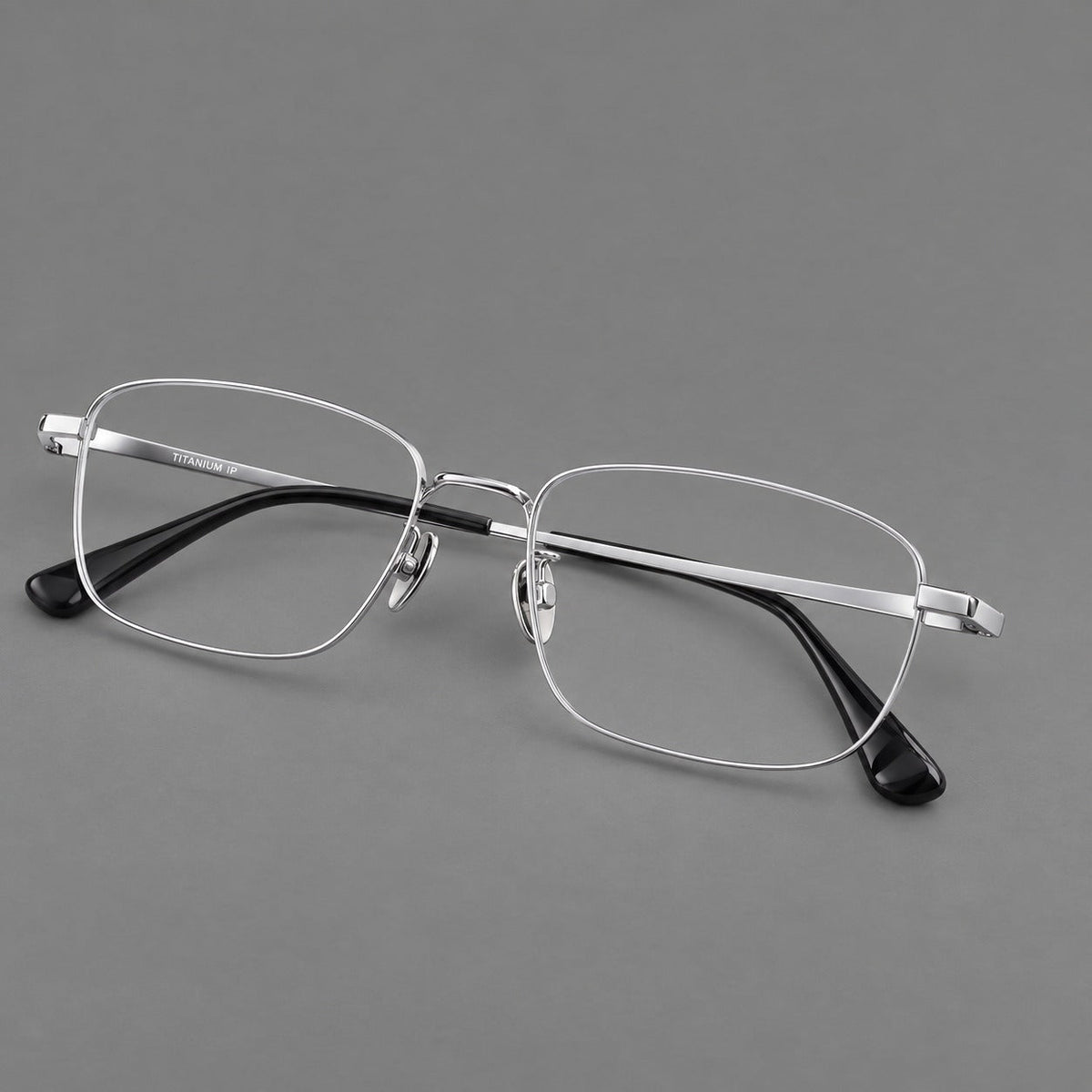 Modern square titanium glasses with an angular bridge and broad straight temples in Silver, three quarter view