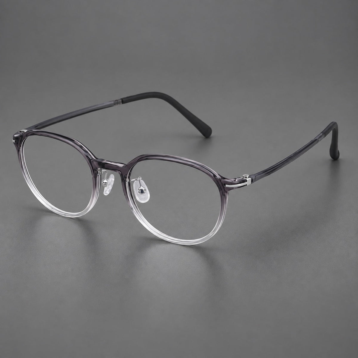 Retro round plastic eyeglasses with a curved bridge and slim metal corner accents in Ink Gray Gradient, three quarter view