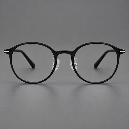 Compact round plastic eyeglasses with gently lifted corners and clear nose pads in Glossy Black, front view side view