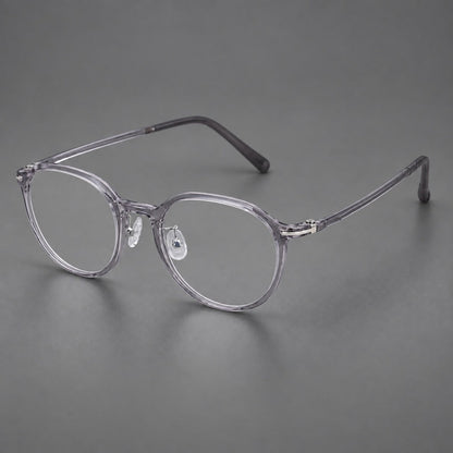 Compact round plastic eyeglasses with gently lifted corners and clear nose pads in Clear Gray, three quarter view front view