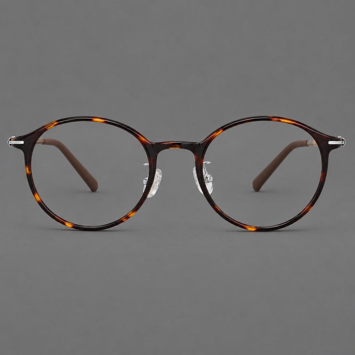 Compact round plastic eyeglasses with gently lifted corners and clear nose pads in Tortoiseshell, front view