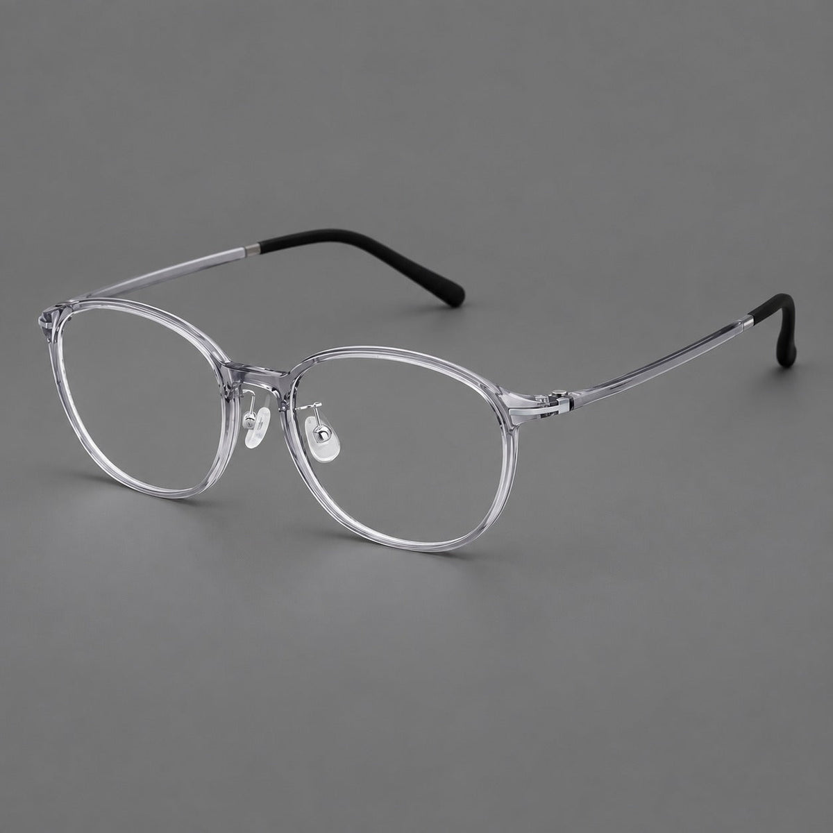 Slim oval plastic eyeglasses with a low profile and subtle metal corner accents in Clear Gray, three quarter view