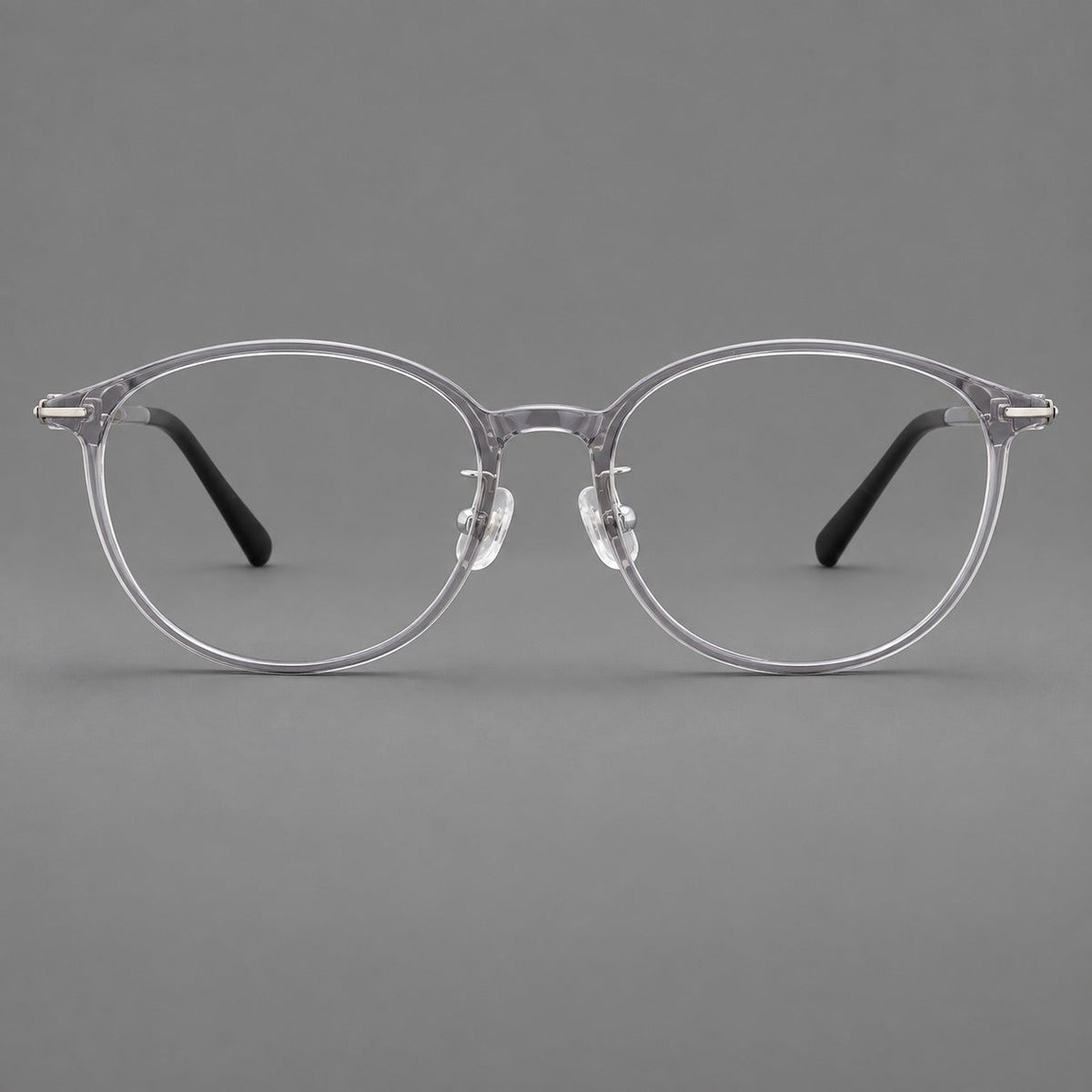 Slim oval plastic eyeglasses with a low profile and subtle metal corner accents in Clear Gray, front view