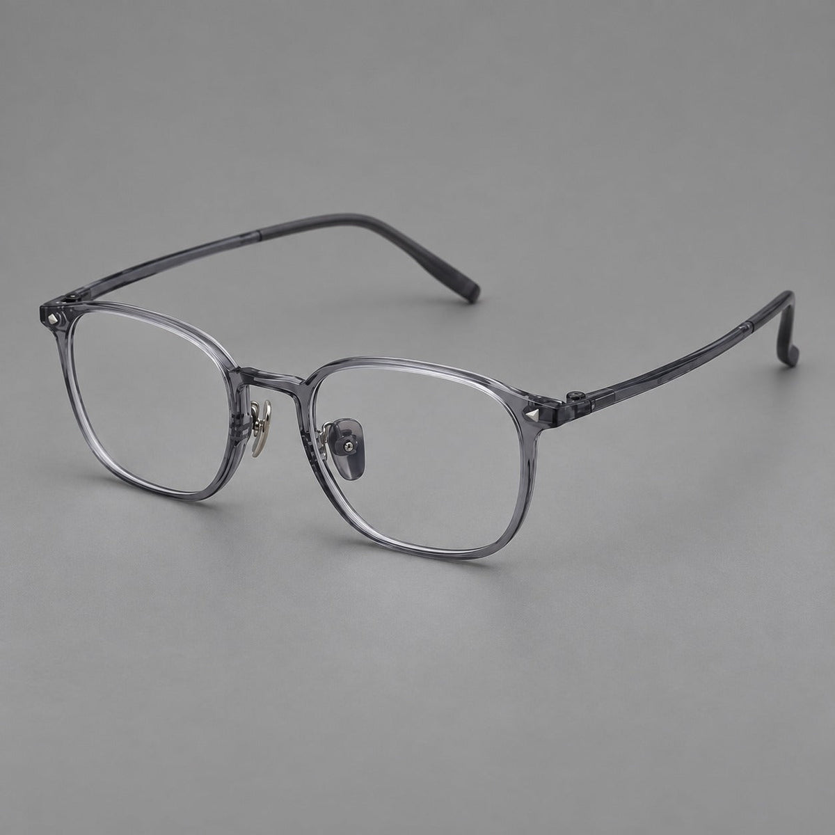 Retro square plastic eyeglasses with a curved bridge and triangular corner details in Ink Gray, three quarter view