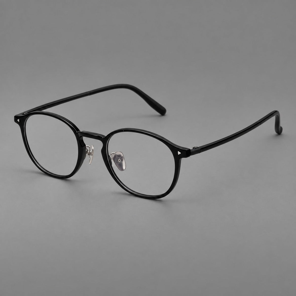 Vintage round plastic eyeglasses with a curved bridge and subtle triangular accents in Glossy Black, three quarter view