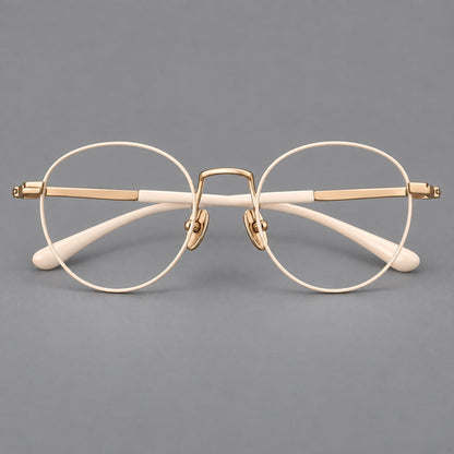 Retro round titanium glasses with a raised bridge and smooth corner shoulders in Cream and Gold, front view temple detail
