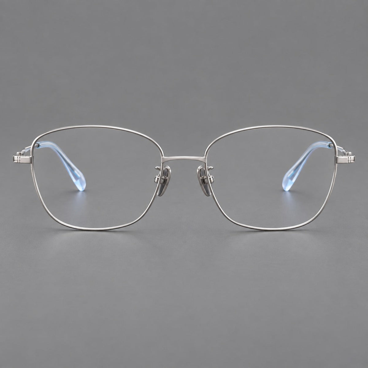 Soft square titanium glasses with angled upper corners and decorated hinges in Silver, front view