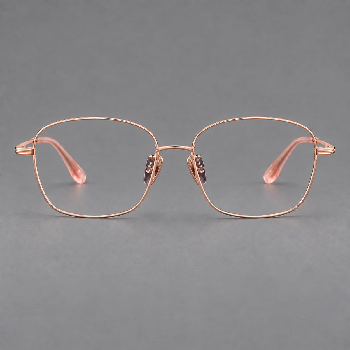 Soft square titanium glasses with angled upper corners and decorated hinges in Rose Gold, front view