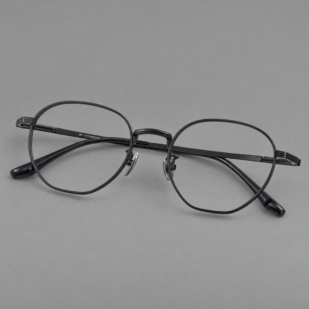 Retro panto titanium glasses with a curved bridge and fine parallel rim grooves in Black, three quarter view