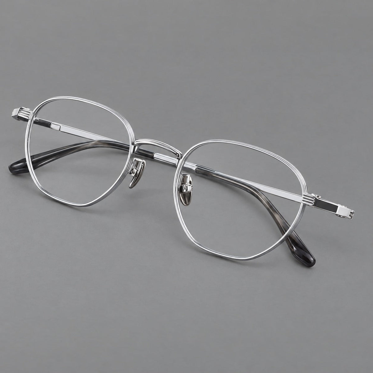 Retro panto titanium glasses with a curved bridge and fine parallel rim grooves in Black and Silver, three quarter view
