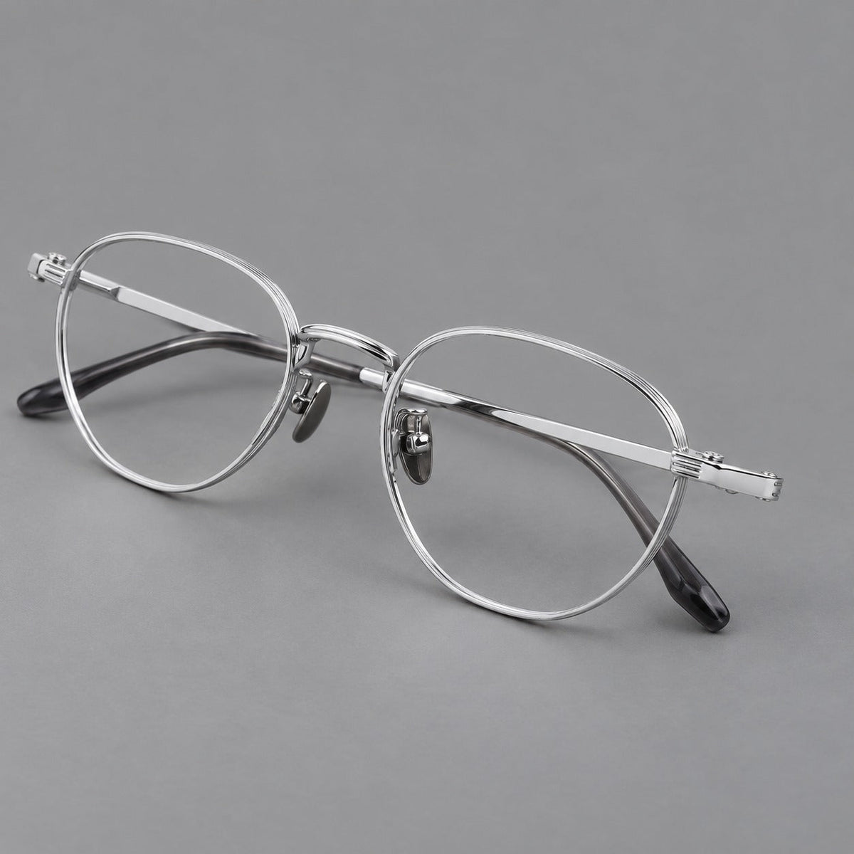 Retro panto titanium glasses with a curved bridge and fine parallel rim grooves in Silver, three quarter view
