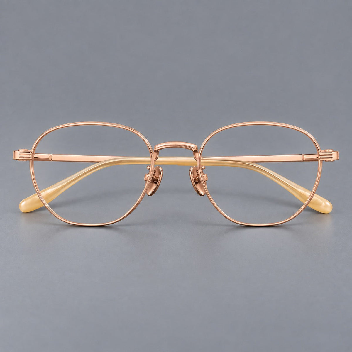 Retro panto titanium glasses with a curved bridge and fine parallel rim grooves in Rose Gold, front view