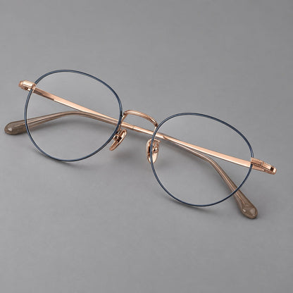 Rounded panto titanium glasses with a raised bridge and dotted temple accents in Blue and Rose Gold, three quarter view front view