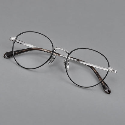 Rounded panto titanium glasses with a raised bridge and dotted temple accents in Black and Silver, three quarter view lens detail