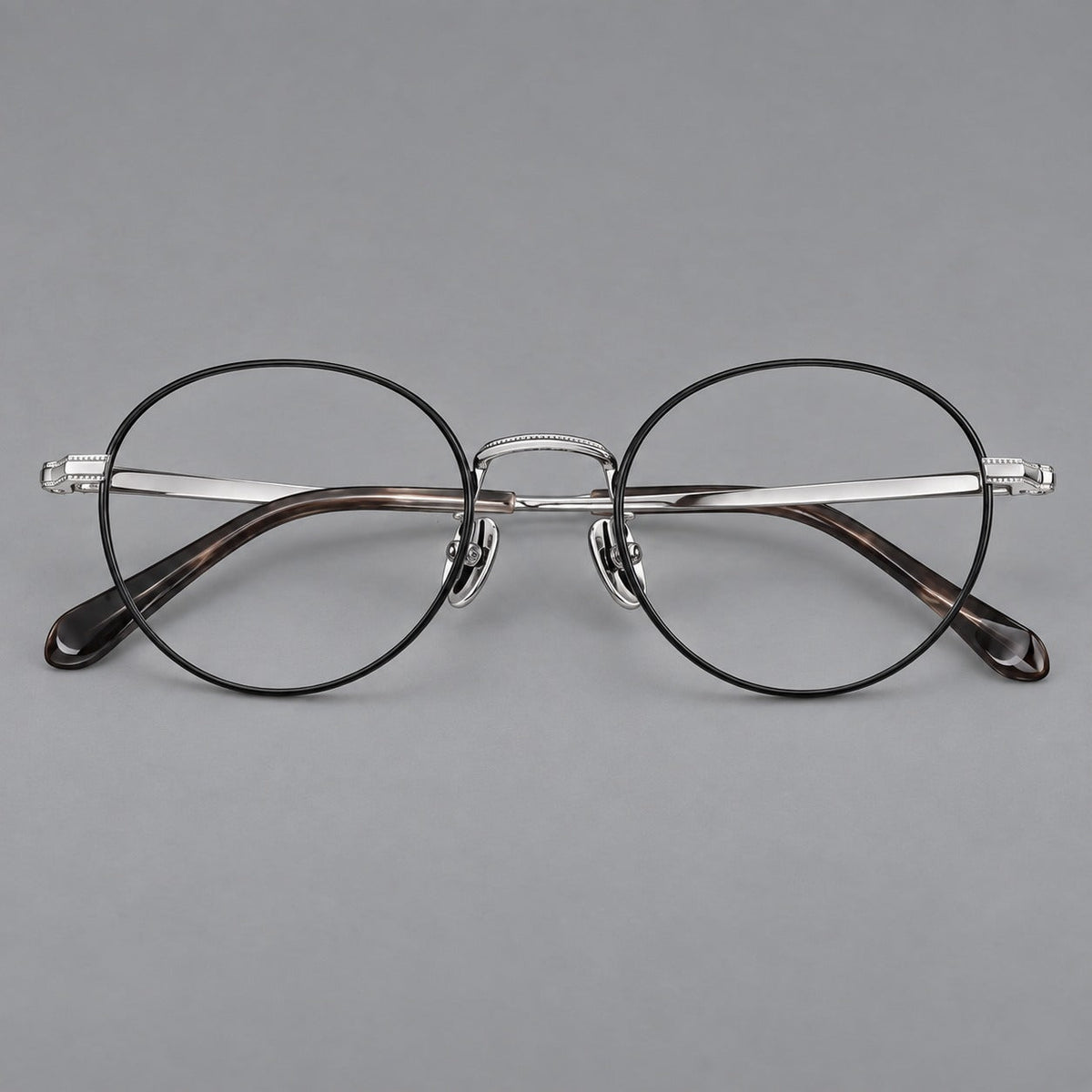 Rounded panto titanium glasses with a raised bridge and dotted temple accents in Black and Silver, front view
