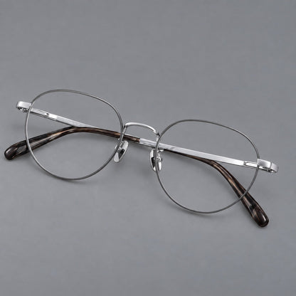 Classic round titanium glasses with broad flat temples and inset hinge details in Gray and Silver, three quarter view front view