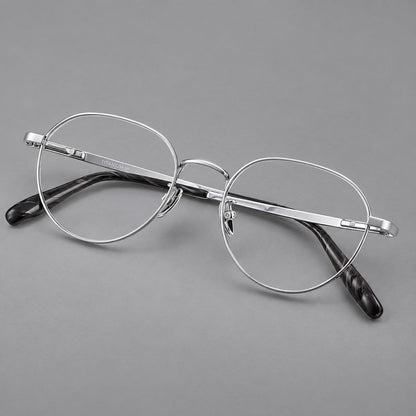 Classic round titanium glasses with broad flat temples and inset hinge details in Silver, three quarter view lens detail