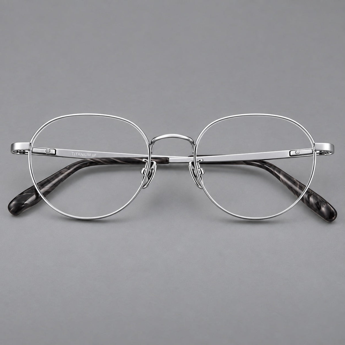 Classic round titanium glasses with broad flat temples and inset hinge details in Silver, front view