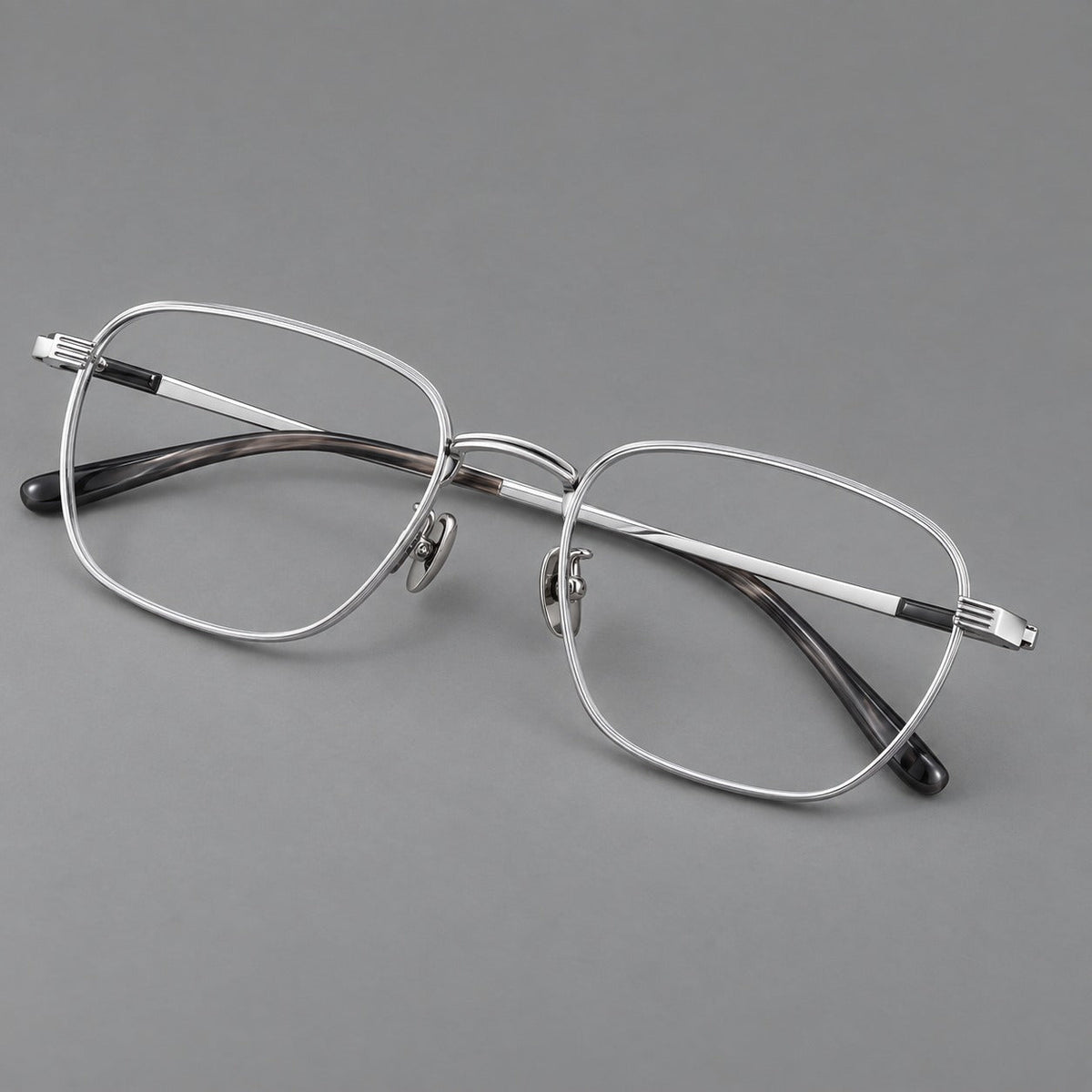Deep square titanium glasses with a flatter brow and grooved outer shoulders in Black and Silver, three quarter view