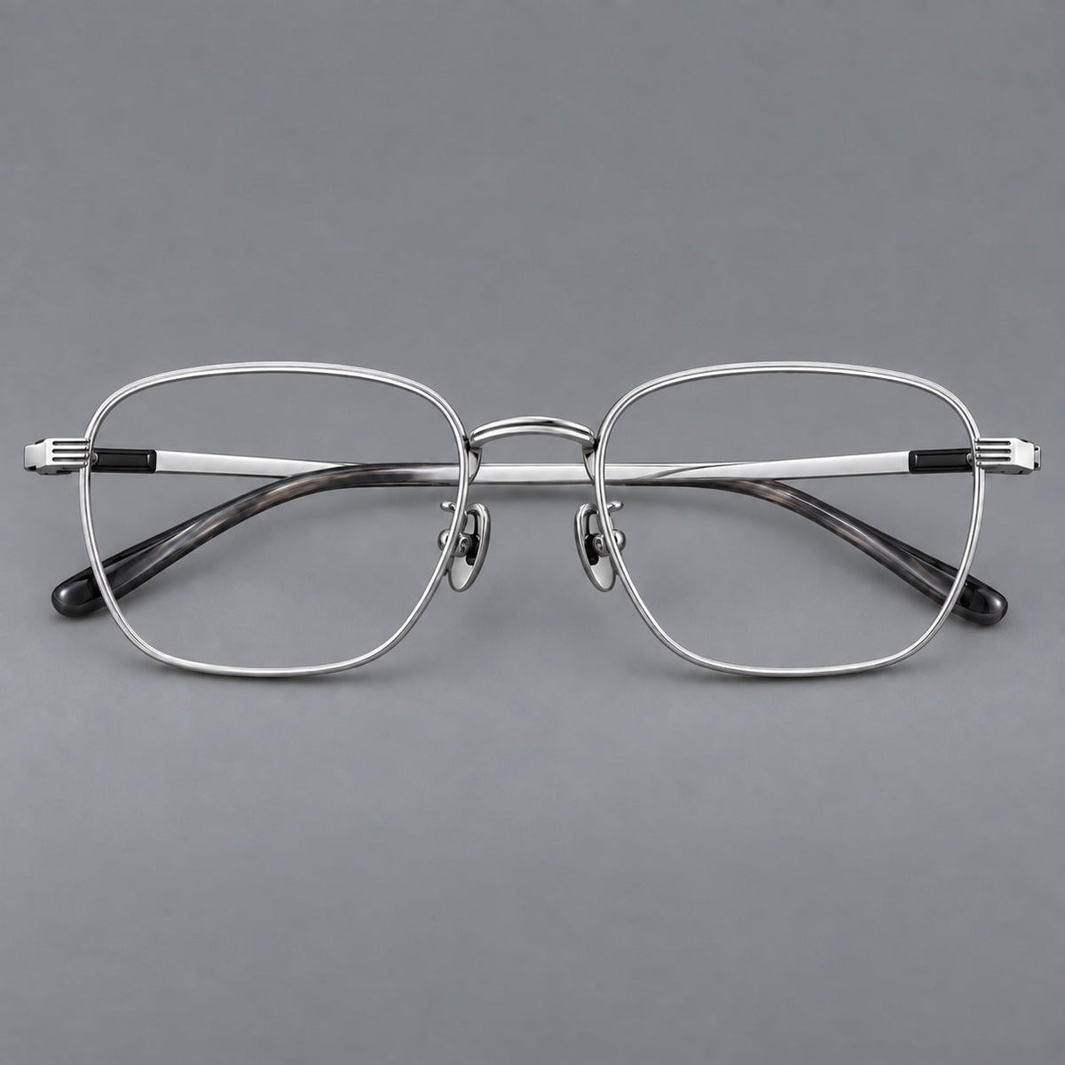 Deep square titanium glasses with a flatter brow and grooved outer shoulders in Black and Silver, front view